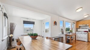 Eine moderne Küche mit weißen Schränken, einem Holzespeisetisch und einem großen Fenster mit Blick auf die Stadt.