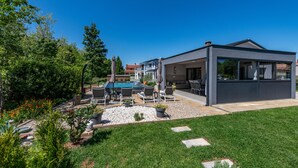 Uma casa moderna com piscina, área de estar externa e varanda coberta.