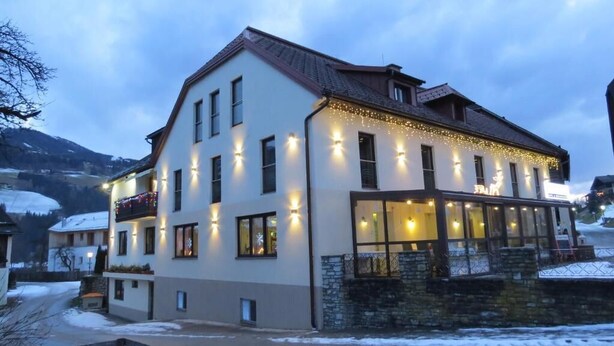 Un hôtel à plusieurs étages, doté d’un éclairage extérieur et de balcons.