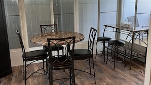 A covered patio area with a round table and chairs, a ceiling fan, and large windows. - Gulfcrest Townhomes Unit 3 (Destin)