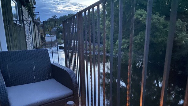 A balcony with a wicker sofa and a lantern. - Riverbank Cottage Lake District, Double Balcony (Egremont)