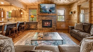 Interior acogedor de una cabaña con chimenea de piedra, paredes de madera, una zona de bar y un espacio de estar confortable.
