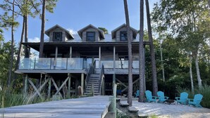 A wooden house with a deck, multiple levels, and a staircase leading to the upper floor. - Sunsets on Water - private beach, pier, boat dock, fishing -12m to Navarre Beach (Navarre)