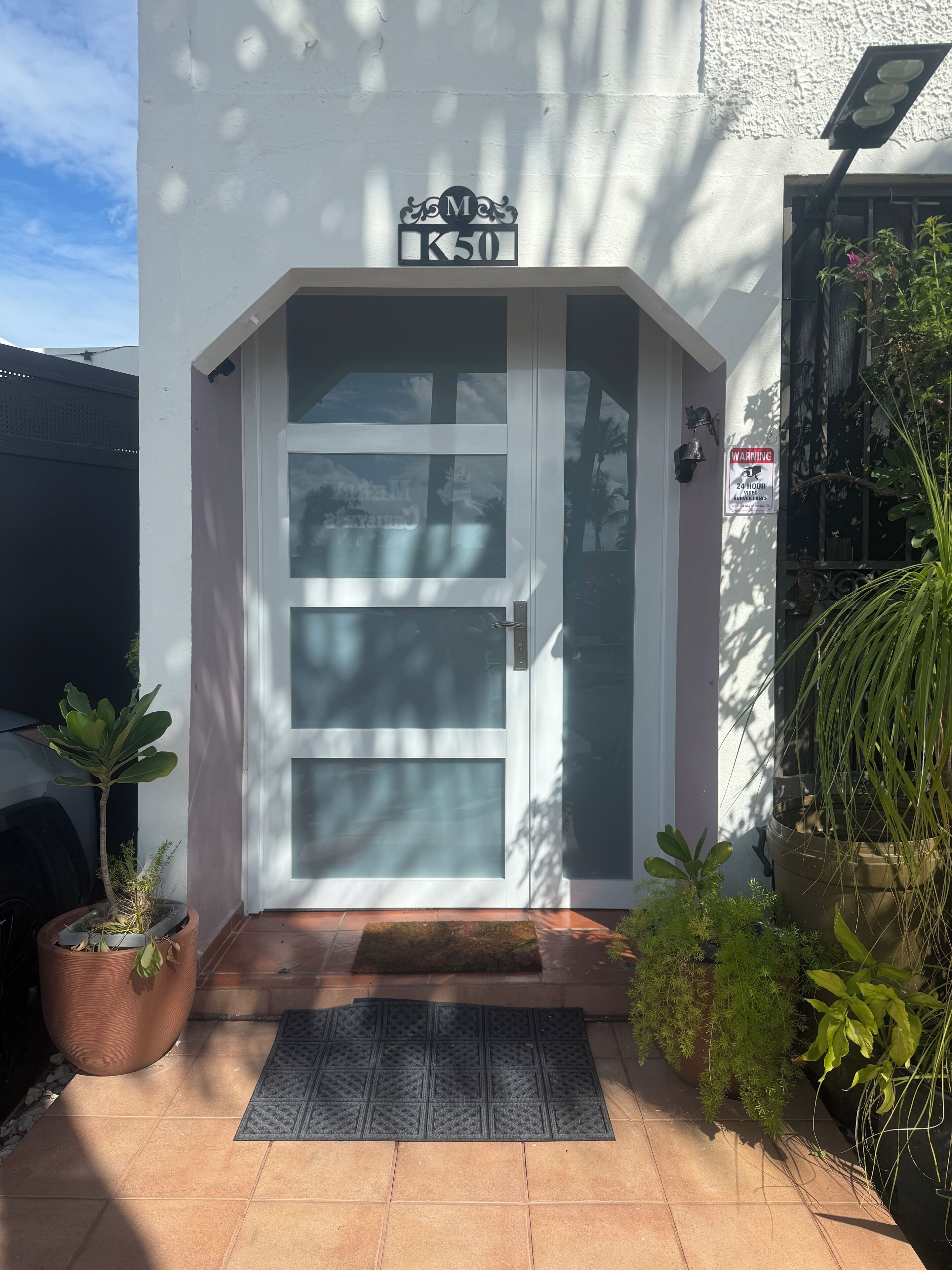 Un edificio blanco con un letrero que dice "M K50" sobre una puerta de cristal.