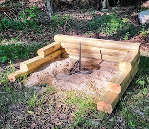 A wooden bench with a metal support structure in a natural setting. - ❤️ Tiny House with Creek Access ❤️ (Anderson)