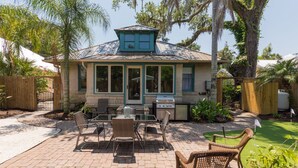 A house with a covered patio, outdoor grill, and seating area. - “Steeped in History” Exquisite 1919 Craftsman (Saint Augustine)