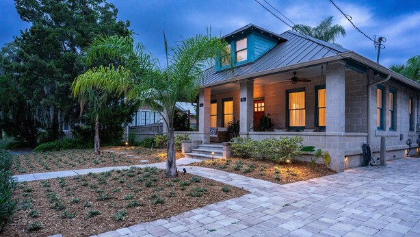 A residential house with a porch, a small front yard, and a brick pathway leading to the entrance. - “Steeped in History” Exquisite 1919 Craftsman (Saint Augustine)