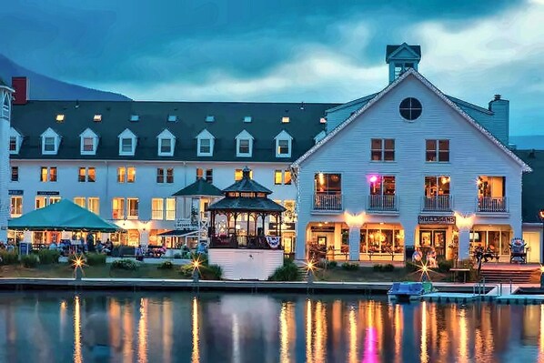 A waterfront hotel with multiple stories, a dock, and a gazebo.