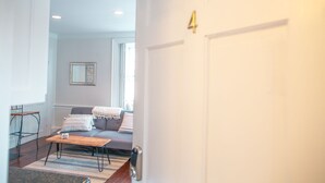 Una sala de estar moderna con un sofá, una mesa de centro y una puerta con un número.