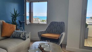 Ein Wohnzimmer mit einer Couch, einem Sessel und einem Tisch mit Schalen und Gläsern.