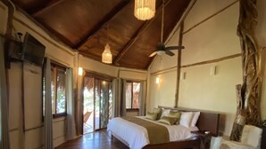 A spacious bedroom with a large bed, wooden flooring, and a ceiling fan. - Villa Marcela (Chetumal)