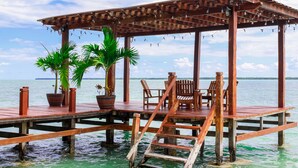 A wooden deck with a pergola, chairs, and potted plants. - Villa Marcela (Chetumal)