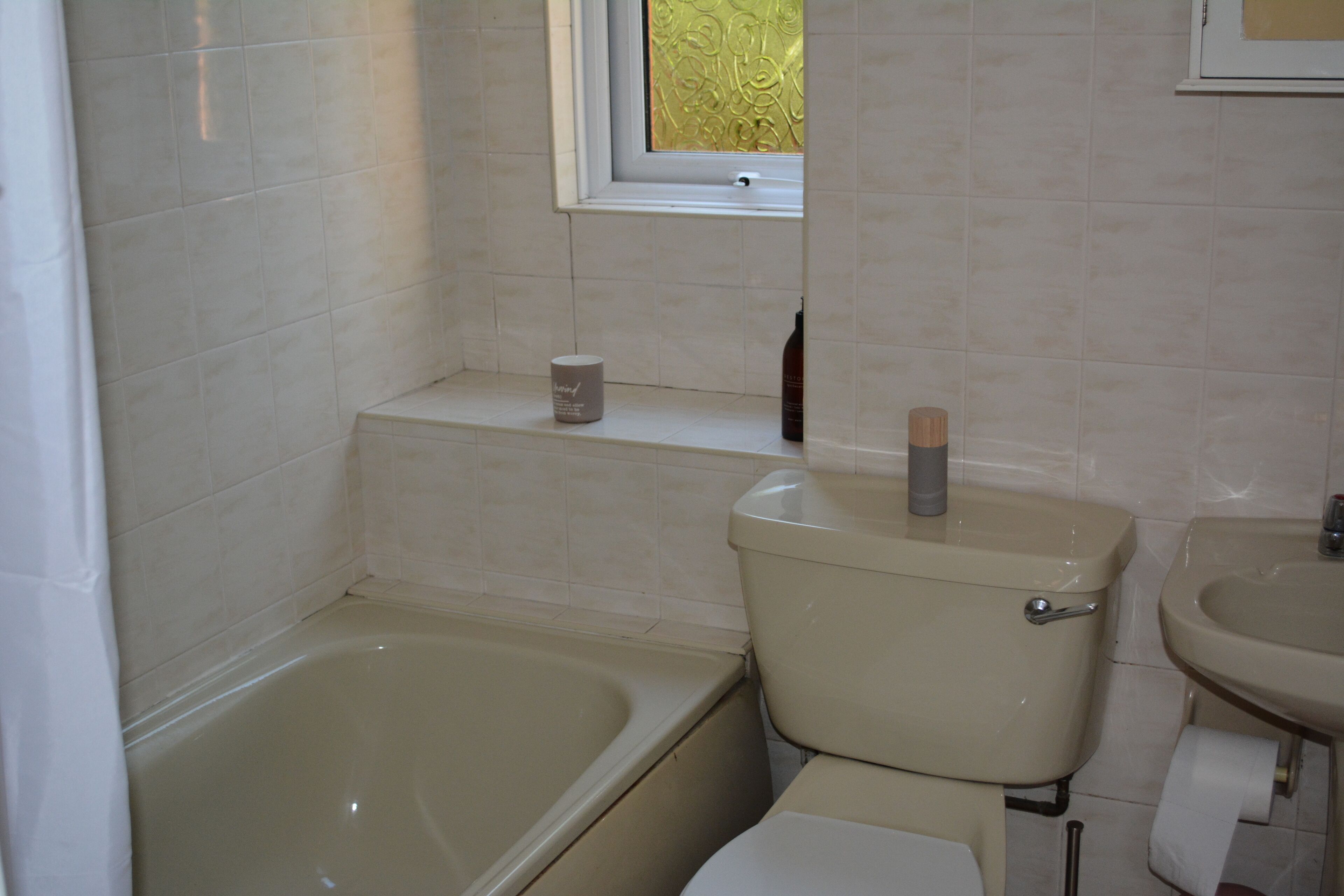 A bathroom with a bathtub, toilet, and sink.