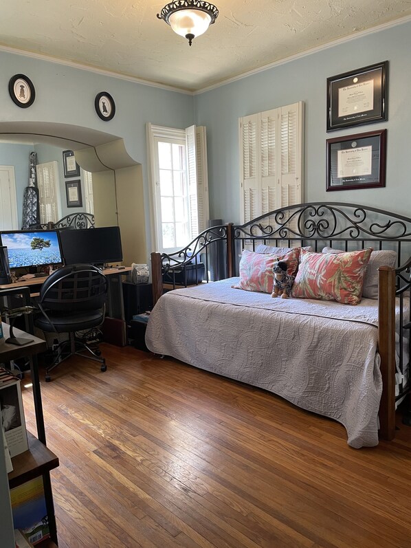 A bedroom with a bed, desk, chair, and a computer.