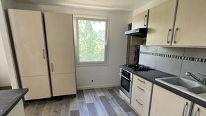 A kitchen with a window, a stove, and cabinets.
