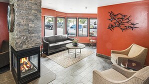 A cozy lobby with a stone fireplace, leather sofa, and wicker chairs. - Westwind 407 (Vail)