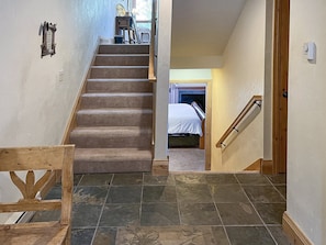 Stairs lead to a cozy bedroom with a bed and window.