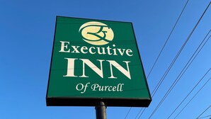A sign for the Executive Inn of Purcell with a clear blue sky in the background. - Executive Inn of Purcell (Purcell)