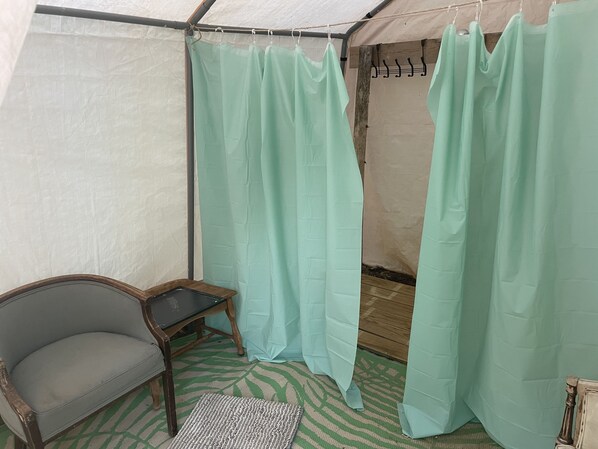 Una tienda con piso estampado color verde, una silla de madera y una cortina colgante.
