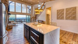 A spacious kitchen with a large island, wooden flooring, and a view through large windows. - Big Sky 2 - Hot tub & game room (Epworth)