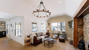 A spacious living room with a fireplace, a large chandelier, and a cozy seating area. - NEWLY RENOVATED Pet Friendly Home (Big Bear Lake)