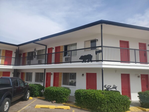 A two-story motel with red doors and balconies.