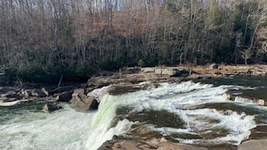 A waterfall cascading over rocks in a forested area. - Falls Market Inn Riverview, Bike Trail, Fallingwater Hotel, 1 KIng Bed 1 Futon (Ohiopyle)