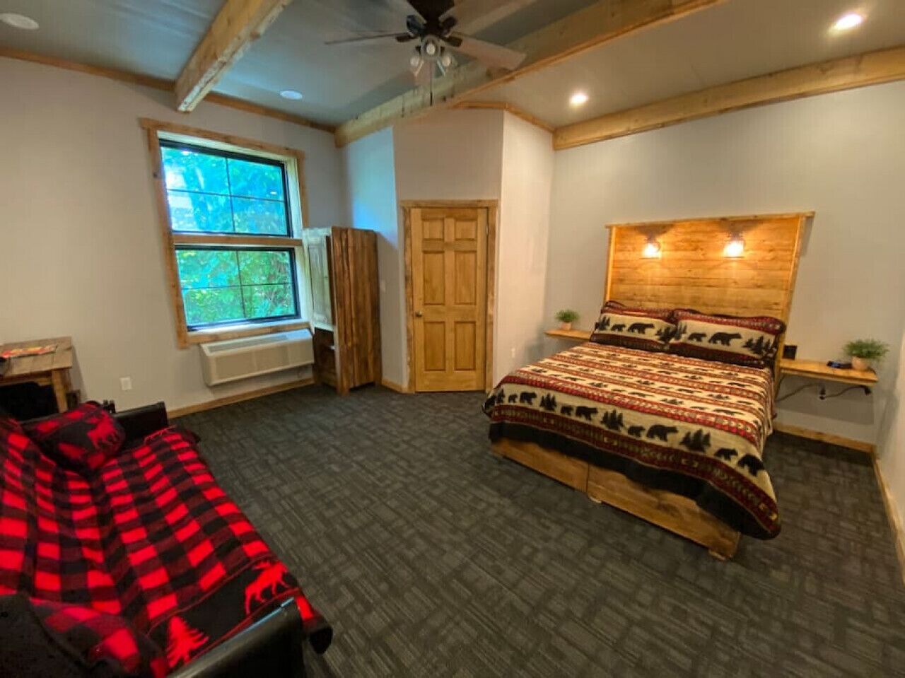 Un dormitorio con cama, ventana, puerta y ventilador de techo.