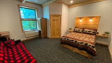 Un dormitorio con cama, ventana, puerta y ventilador de techo.