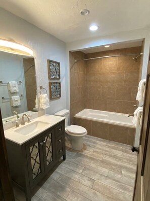 Une salle de bain moderne équipée d’un meuble-lavabo, d’un lavabo, de toilettes et d’une baignoire.