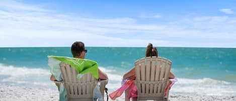 Guests can relax on the beach with ocean views.