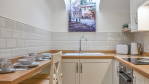 A kitchen with a wooden countertop, white cabinets, a sink, and a toaster. - The Stables at Early Autumn (Sevenoaks)