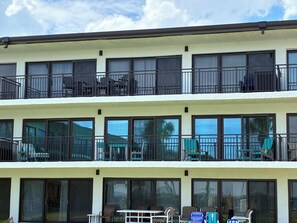 Un hotel de varios pisos con balcones, grandes ventanales y terrazas al aire libre.