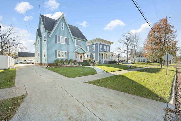 A two-story house with a front yard and driveway. - Comfy Flat with Old World Charm in the city (Jackson)