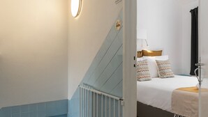 A staircase with blue and white walls, a wooden handrail, and a metal railing. - Casa Casulo - 2min walking to the Beach (Nazaré)