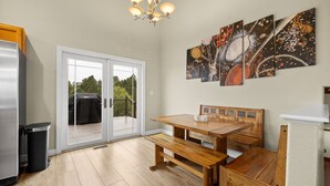 Une cuisine avec une table en bois, un banc et une grande fenêtre.