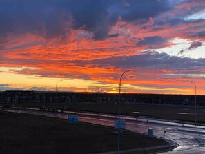 Un atardecer sobre una zona residencial con casas y una carretera.