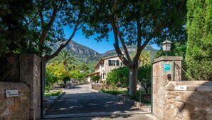 A stone gate leading to a house with a mountain backdrop. - Sa Finqueta Luxury Elegant Mansion with breathtaking views in Sóller (Sóller)