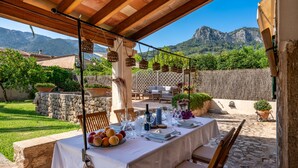 An outdoor dining area with a table set for two, surrounded by stone walls and potted plants. - Sa Finqueta Luxury Elegant Mansion with breathtaking views in Sóller (Sóller)