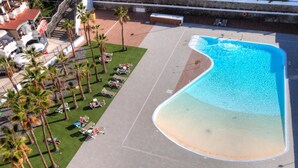 An aerial view of a resort with a large swimming pool, palm trees, and sun loungers. - Stylish Friendly Holiday Home (Playa del Inglés)