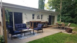 A covered patio with a sofa, chairs, and a table.
