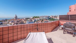 A rooftop terrace with a view of a cityscape, including a dome building and various buildings.