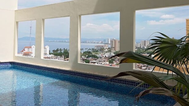 A rooftop pool with a clear view of a cityscape and the sea. - Beautiful, Airy Condo Near Boardwalk**** (Puerto Vallarta)