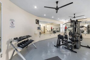 A gym with exercise equipment, a ceiling fan, and a mirror. - Beautiful, Airy Condo Near Boardwalk**** (Puerto Vallarta)