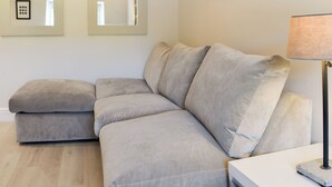 Una sala de estar moderna con un sofá modular, una mesita auxiliar y una lámpara de pie.