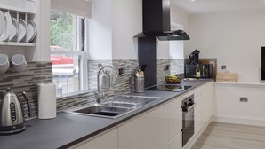 A modern kitchen with a large island, stainless steel appliances, and a view of the outdoors. - 2 bedroom accommodation in Newburgh, near Cupar (Newburgh, near Cupar)