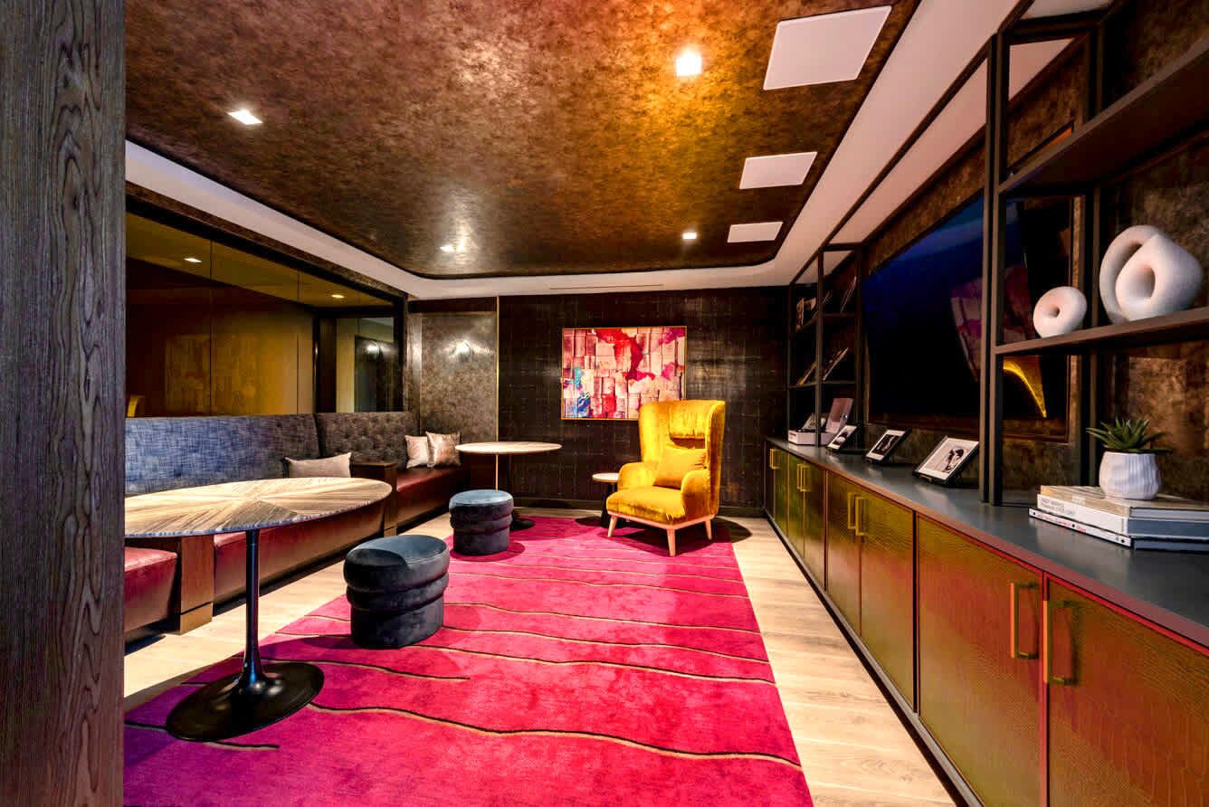 Un intérieur moderne avec un tapis rouge, un fauteuil jaune, une table ronde et un canapé.