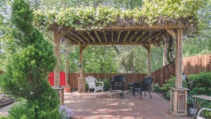 A patio with a pergola, two chairs, a table, and a fire pit. - Boonville Luxury Lodging (Boonville)
