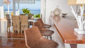 A coastal bar area with wicker chairs and a wooden bar counter. - Luxury Villa in the French Carribean with a stunning view (Vieux Fort)