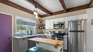 A kitchen with white cabinets, stainless steel appliances, and a wooden island. - The GreenHouse - walk to the heart of Palmer, AK (Palmer)